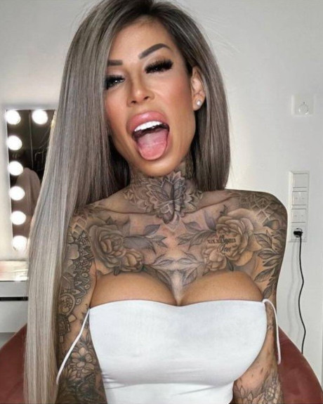 Tattooed amateur babe poses in pink fishnets & flaunts her hot legs & cleavage - #161804