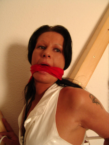 Brunette skank girl is cleave gagged and restrained to a St Andrew's Cross in boots - #170501