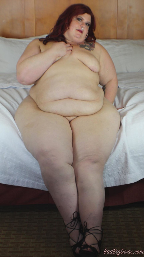 Redhead SSBBW Nikki Cakes shows her monstrous butt while face down on a bed - #179985