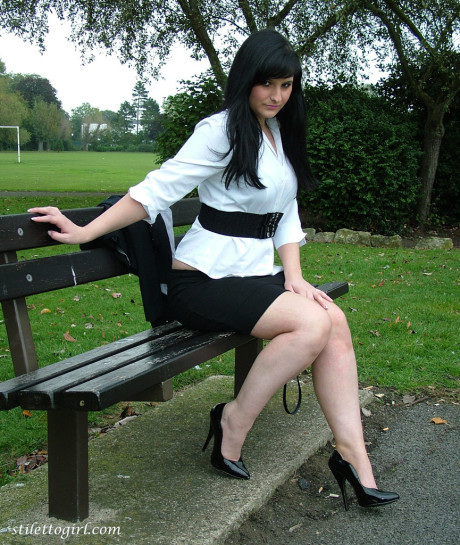 Clothed model Nicola poses on a park bench to show off her attractive legs - #116826