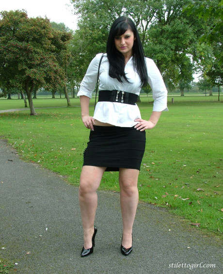 Clothed model Nicola poses on a park bench to show off her attractive legs - #116838